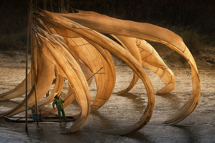 Ένας Κινέζος ψαράς καθώς ο αέρας σηκώνει τα δίχτυα του