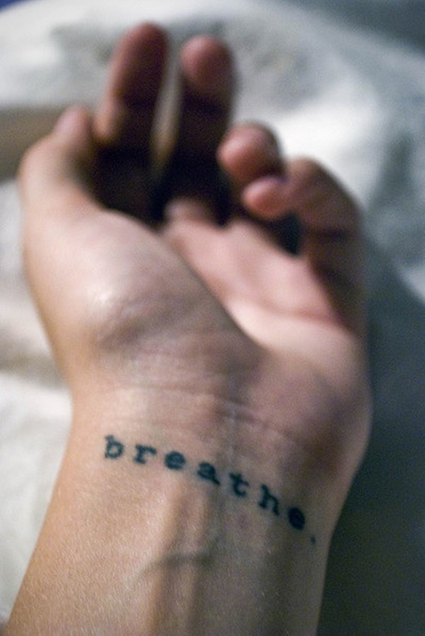Tatuaje de muñeca con frase ‘’respira’’