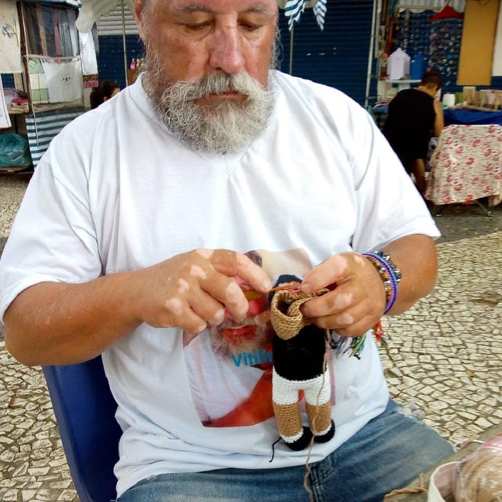 Mężczyzna robi na drutach lalki z bielactwem